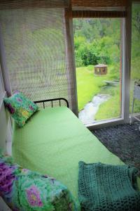 a green bed in a room with a window at River Falls Lodging -Black Hills, South Dakota in Hot Springs