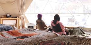 3 femmes assises dans une pièce avec un lit dans l'établissement The Day Post General Glamping Village Yamanakako - Vacation STAY 25051v, à Yamanakako