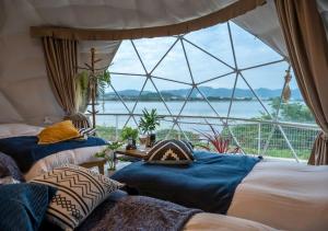 Dos camas en una habitación con una gran ventana. en Glamping Base IZUMO "Lakeside Hot Spring Hotel Kun - Vacation STAY 42021v, en Izumo