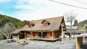 a log cabin with benches in front of it at Logland Okumino - Camp - Vacation STAY 42153v in Gujo