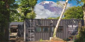 a black building with a mountain in the background at The Day Post General Glamping Village Yamanakako - Vacation STAY 25049v in Yamanakako