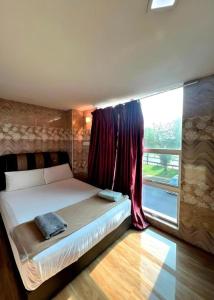 a bedroom with a large bed with a window at Putra Heights New Wave Hotel in Kuala Lumpur