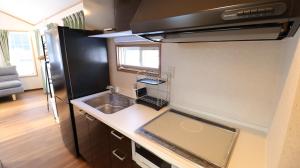 a small kitchen with a sink and a refrigerator at OAK VILLAGE - Camp - Vacation STAY 42131v in Hakuba