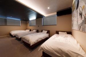 three beds in a room with white sheets at GranTerace Sun - Vacation STAY 15256 in Numazu