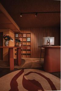 a room with a desk and a table with a vase of flowers at SKIPR Hotel in Antwerp