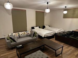 a living room with a couch and a bed at Tsunageru Aomori Yasukata - Vacation STAY 25824v in Aomori