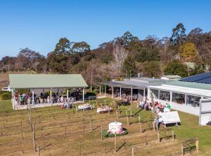 un gruppo di persone in piedi fuori da un edificio di The Dairy at Cambewarra Estate Winery a Camberwarra