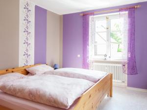 two beds in a bedroom with purple walls and a window at Charmante Ferienwohnung Katja in Morbach-Hoxel in Morbach +21 photos
