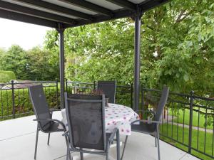 a patio with a table and chairs and a fence at Morscheid-Riedenburg Stay in Morbach