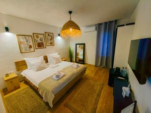a bedroom with a large bed and a tv at Garden Relax Bungalow "Deluxe Hotel Rooms, Pool, Parking" in Banja Luka