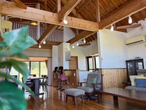 a living room with wooden ceilings and tables and chairs at Inori Resort SORAKAZE - Vacation STAY 49443v in Shushi