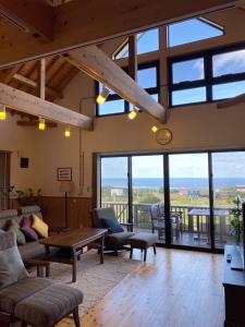a living room with large windows and a table at Inori Resort SORAKAZE - Vacation STAY 49443v in Shushi