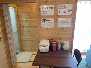 Una habitación con una pared de madera con una mesa con dos tostadoras. en Koniyado Room 103 - Vacation STAY 42437v, en Setouchi