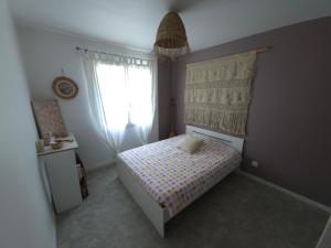 a small bedroom with a bed and a window at Charmante maison de vacances in Saint-André-de-Cubzac