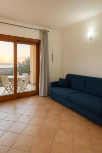 バデージにあるSunset View Apartment and Pool Badesiのリビングルーム(青いソファ、バルコニー付)