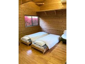 a bedroom with two beds in a log cabin at Nanakuniyama Minka - Vacation STAY 37250v in Isumi