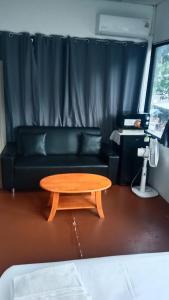 a living room with a table and a couch at Papaya House Koh Tao in Ko Tao +3 photos