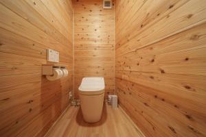 a bathroom with a toilet in a wooden wall at Osugi no Yado - Vacation STAY 43977v in Yufuin +36 photos