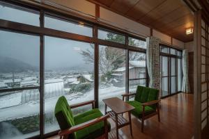 a room with green chairs and a large window at Osugi no Yado - Vacation STAY 43977v in Yufuin
