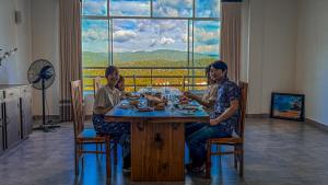 three people sitting at a table in a room with a window at Red Chillies Nature Inn in Kandy +36 photos