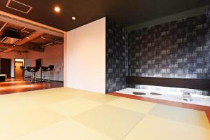 een kamer met een tegelmuur en een toonbank met stoelen bij Pleasure Maruyama - Vacation STAY 52780v in Sapporo +18 foto's