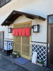 a building with a gate with a red curtain on it at Maison dEssence - Vacation STAY 52767v in Izu