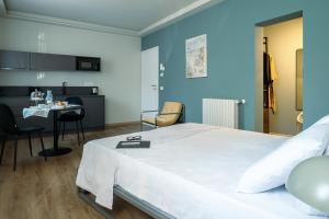 a bedroom with a large white bed and a table at La Croce Apartments in Castelnovo neʼ Monti