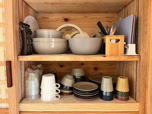 a wooden shelf with bowls and plates and other kitchen utensils at Matsu no Yu Tokiwa - Vacation STAY 56390v in Yatsushiro