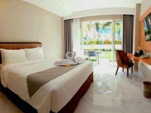 a hotel room with a large bed and a desk at Rama Garden Hotel in Palu +63 photos