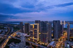 Atour Hotel Wuhan Hankou Riverside Park, Jiefang Avenue في Jiang'an: أفق المدينة مع المباني الشاهقة والجسر