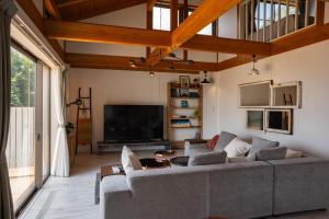 Una sala de estar con un sofá y un televisor. en Sae Garden KAMOGAWA - Vacation STAY 59199v, en Kamogawa