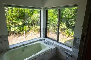 - Baño con bañera y 2 ventanas en Sae Garden KAMOGAWA - Vacation STAY 59199v, en Kamogawa