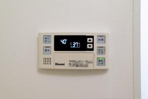 an electronic clock hanging on a white wall at VIDA Hakata 301 - Vacation STAY 63191v in Sumiyoshi