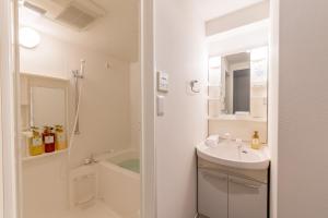 a white bathroom with a sink and a bath tub at VIDA Hakata 301 - Vacation STAY 63191v in Sumiyoshi +45 photos