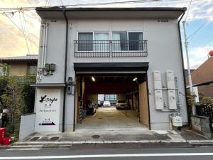 a building with a garage with a car in it at K-style Nishijin backpackers - Vacation STAY 17739 in Kyoto