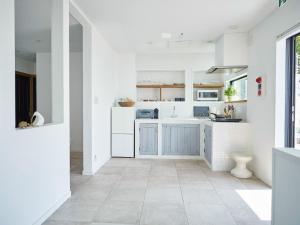 a kitchen with white cabinets and a tile floor at &SUN Terrace house - Vacation STAY 67119v in Yokosuka