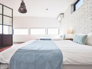 a bedroom with a large bed and a brick wall at &SUN Terrace house - Vacation STAY 67119v in Yokosuka