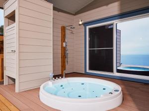 a bath tub in a room with a large window at &SUN Hung five - Vacation STAY 67613v in Minamiboso +11 photos