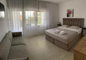 a bedroom with a large bed and a couch at Room with Balcony and Sea View in Zadar