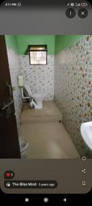 a bathroom with a toilet and a sink and a window at The Bliss Mind in Almora