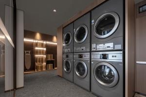 Atour Hotel Long'an Lake Linping في هانغتشو: غرفة غسيل مع اربع غساله ونشافه