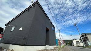 a black building on the side of a street at Toyoura Ocean House - Vacation STAY 15447 in Toyoura