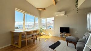 a living room with a table and a large window at Toyoura Ocean House - Vacation STAY 15447 in Toyoura