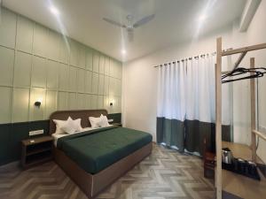 a bedroom with a green bed and a ceiling fan at Whitepoppy Hostel in Udaipur