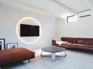 a living room with a couch and a tv on the wall at &MOON Noa - Vacation STAY 72009v in Hayama