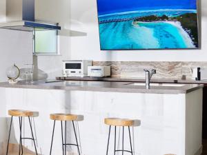 a kitchen with a counter with two bar stools at SAJIMA Funny house - Vacation STAY 15436 in Hayama +16 photos