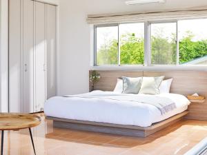 a bedroom with a large bed and two windows at SAJIMA Funny house - Vacation STAY 15436 in Hayama