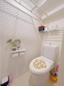 ein weißes Badezimmer mit einer Toilette mit Blumensitz in der Unterkunft JINGHOUSE Takasago detached house - Vacation STAY 17050 in Tokio