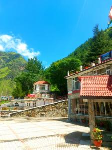 a group of buildings with mountains in the background at Mashoo Resort in Shamshi