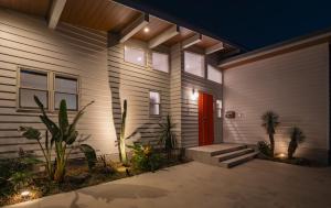 a house with a red door and some plants at MIYAZAKI BASE in aoshima - Vacation STAY 82721v in Miyazaki